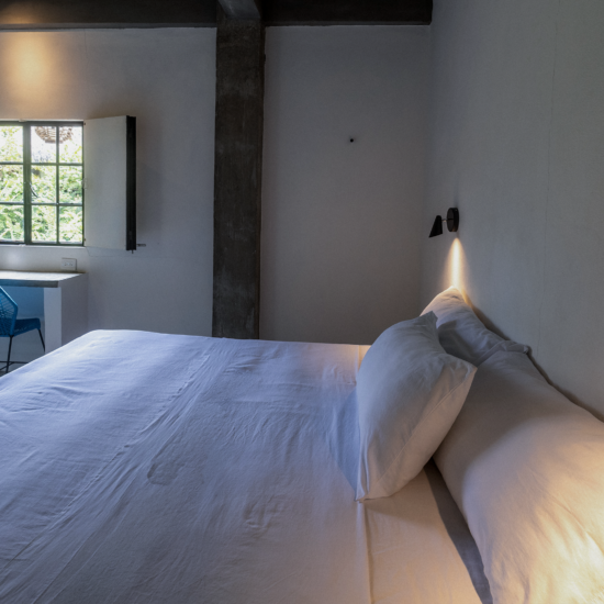 King-size bed and window overlooking tropical greenery in Soirée’s King Bedroom